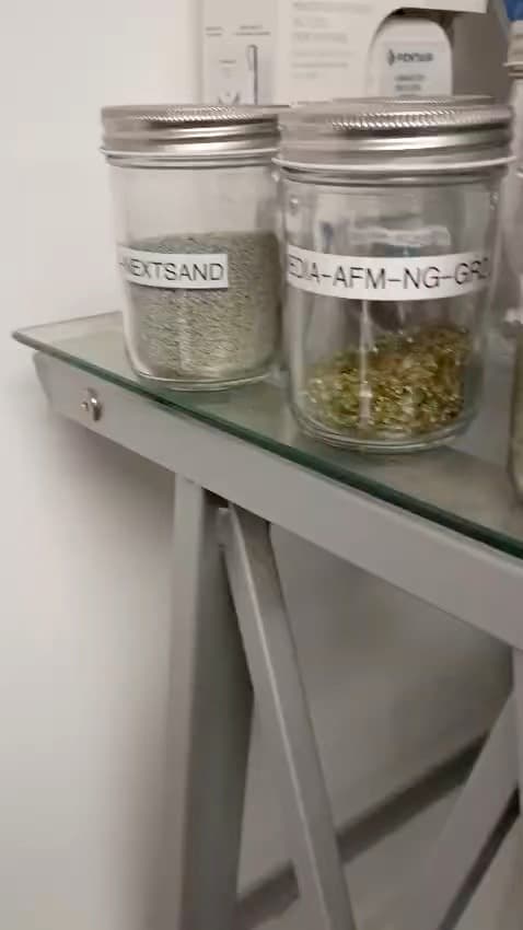 Labeled jars of filtration media on a shelf in the Falcon shop